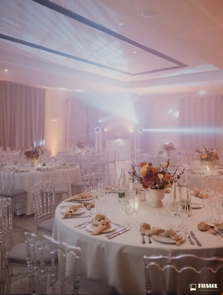 Salle de réception dressée, centre de table fleuri et bougies